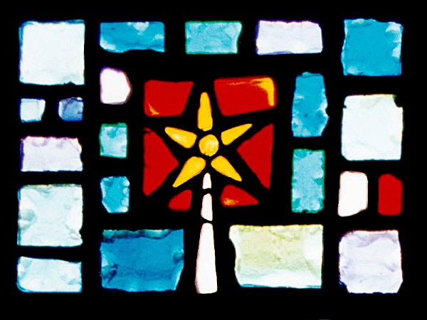 stained glass panel with blocks of blue, yellow, and red glass forming a star